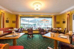 Frühstücksraum mit Sitzgelegenheiten im Hotel Garni Almenrausch und Edelweiß in Garmisch-Patenkirchen